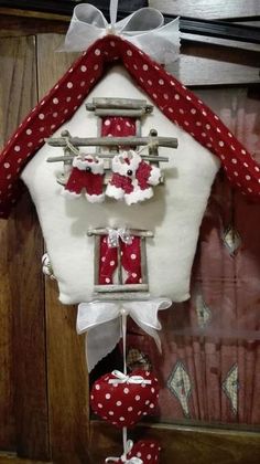 a red and white house with polka dot decorations on the front door hanging from a hook