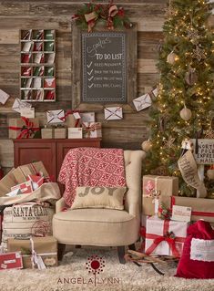 a christmas tree and presents in front of a wooden wall