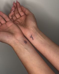 two hands holding each other with small tattoos on their wrist and the letter f tattooed above them