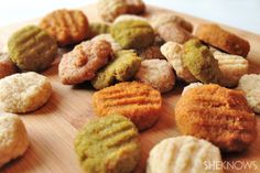 a wooden cutting board topped with different types of cookies