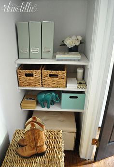 an elephant statue sitting on top of a wooden floor next to baskets and boxes in front of a door