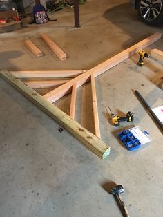 some wood is laying on the floor next to tools and screwdrivers in a garage