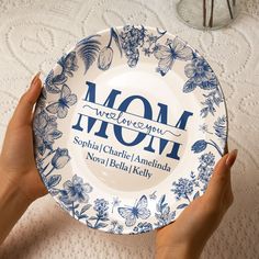 two hands holding a blue and white plate with the words, mom we love you