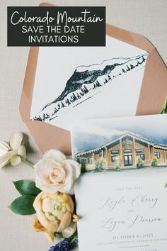 the wedding stationery is laid out on top of an envelope with flowers and greenery