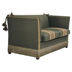 an upholstered couch with tassels on the back