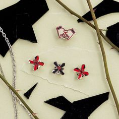 three red and black crosses sitting on top of a piece of paper next to a pair of scissors