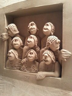 a group of ceramic monkeys sitting in a niche with their heads pressed into the wall