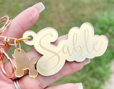 a person holding two personalized keychains in their hand with the word sale written on them