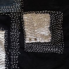 the black and white quilt is made up of square pieces of fabric with small squares on them