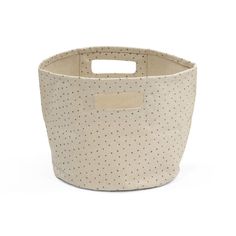 a small white basket with polka dots on the front and bottom, sitting on a white surface