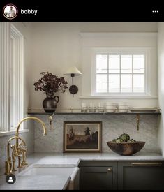 a kitchen with marble counter tops and gold faucets on the wall above it