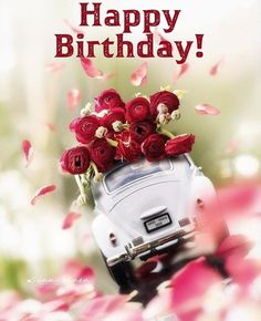 a white vw bus with red flowers in it's trunk and the words happy birthday