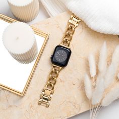 an apple watch sitting on top of a table next to cupcakes and a mirror