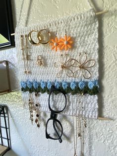 there is a wall hanging with many different items on it, including scissors and necklaces