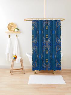 a bathroom with a blue shower curtain and white rug on the floor next to it