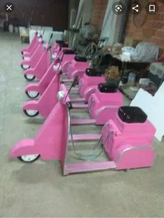 several pink scooters are lined up in a row on the floor next to each other