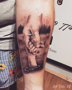 a man with a tattoo on his arm holding the hand of another person