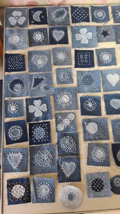 a table topped with lots of different pieces of cloth covered in white thread on top of a wooden surface