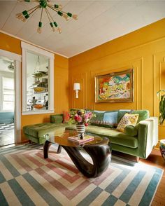 a living room with yellow walls and green furniture