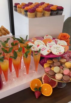 an assortment of desserts and pastries displayed on a table in front of cupcakes