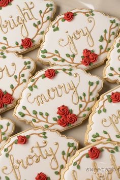 decorated cookies with red roses on them are arranged in a row and the words happy, merry