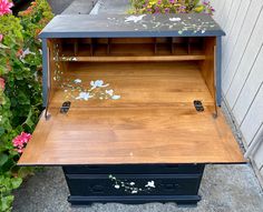 an old fashioned wooden box with flowers growing out of it