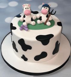 the cake is decorated with black and white cows