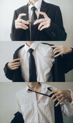 a man wearing a suit and tie with his hands on the shirt's chest