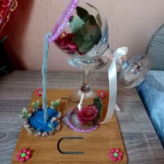 a wine glass is being filled with water from a faucet on a wooden stand