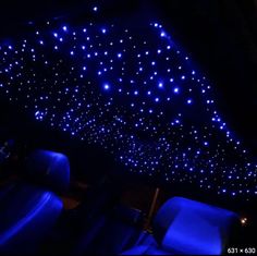 the interior of a car with blue lights on it and seats in front of them