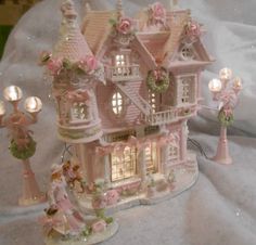 a pink doll house with lights and decorations