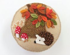 a hedge and mushroom brooch with leaves on it