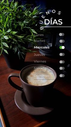 a cup of coffee sitting on top of a table next to a potted plant