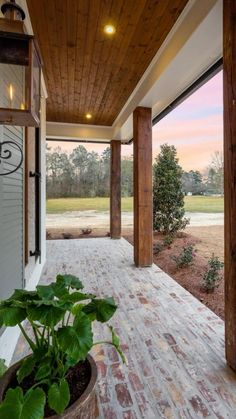 the porch is covered with wood and has a potted plant in front of it