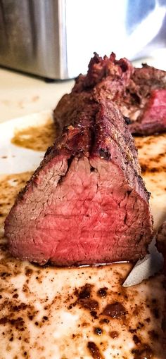 a piece of steak on a plate with sauce and gravy next to an instant pot roaster