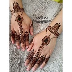 two hands with henna tattoos on them