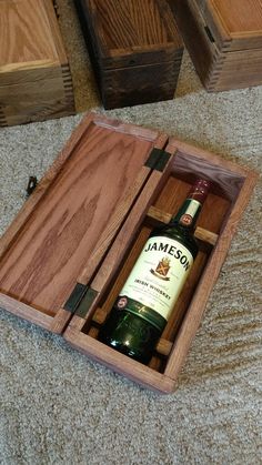 a bottle of jameson is in a wooden box on the floor next to some drawers