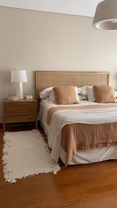 a large bed sitting on top of a hard wood floor next to a night stand