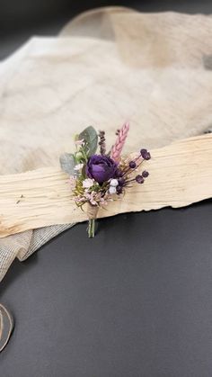 a bouquet of flowers sitting on top of a piece of wood