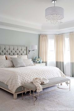 a bedroom with a large bed and chandelier