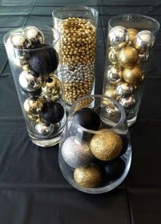 several glass vases with ornaments in them on a black table cloth covered tablecloth