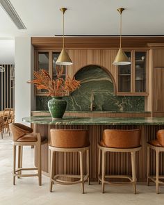 a kitchen with marble counter tops and wooden stools in front of an island bar