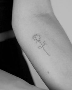 a single rose tattoo on the left arm and right arm, is shown in black and white