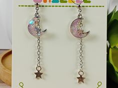 These lovely earrings are perfect for the astrology lover in your life!  Each charm is made from resin dyed in pastel colors with a splash of glitter poured into a tiny metal frame, then the details are hand painted before the whole thing is sealed in a layer of clear resin to protect the mini work of art!    Earrings measure around 2 inches in length with stud findings. Findings are nickel and lead free. Please remove from wearing before swimming or showering. *Note- Hand crafted resin pieces usually have small flaws such as air bubbles. I try to limit these as much as possible and most will be unnoticeable. These flaws won't cause any damage to the piece and are no cause for concern, but they're part of what makes handmade resin pieces unique and one of a kind! Adjustable Kawaii Dangle Earrings, Silver Hypoallergenic Kawaii Earrings, Hypoallergenic Silver Kawaii Earrings, Silver Dangle Kawaii Jewelry, Moon Phase Star Earrings For Gift, Handmade Kawaii Silver Earrings, Handmade Silver Kawaii Earrings, Magical Nickel-free Earrings For Gifts, Nickel-free Magical Earrings For Gift