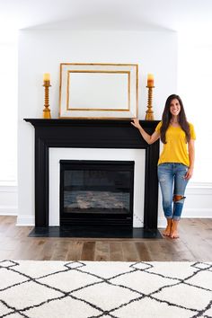 a woman standing next to a fire place in a living room