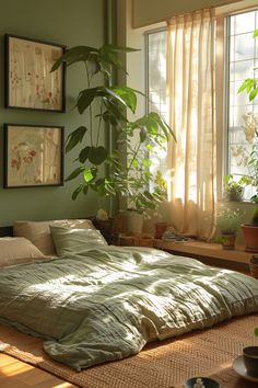 an unmade bed sitting in front of a window next to a potted plant