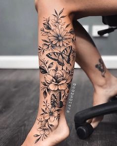 a woman's leg with flowers and butterflies on it