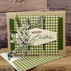 a christmas card with green and white plaid paper, holly leaves and berries on it