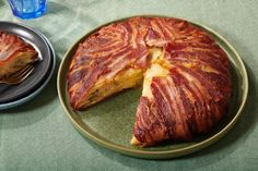 a bacon cake on a plate with a slice cut out and ready to be eaten