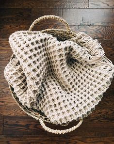 a crocheted bag sitting on top of a wooden floor